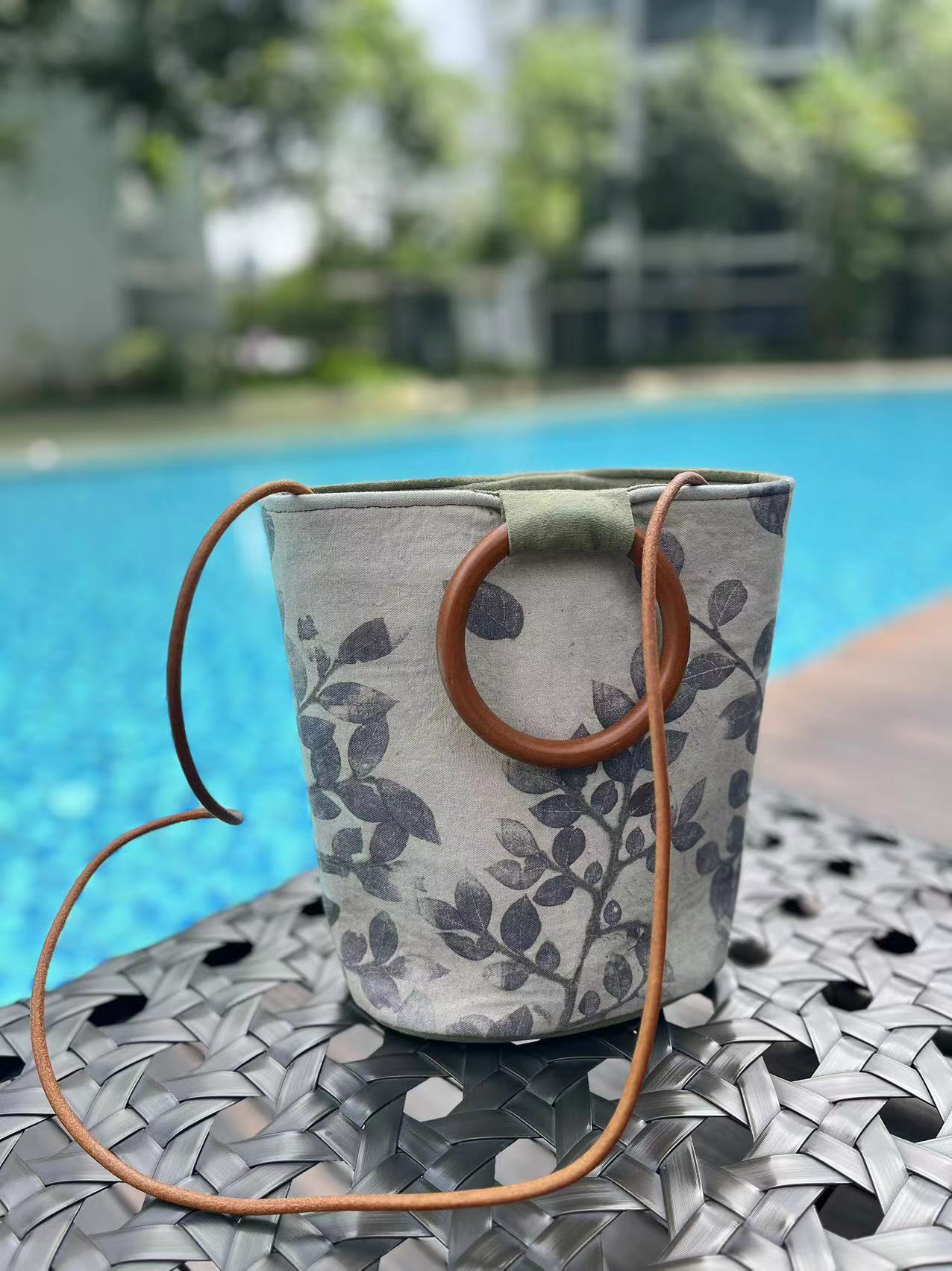 Natural eco dyeing bucket bag within the real leaves thermal transfer fabric. Natural perilla light green dyeing handle bag with solid wood handles.