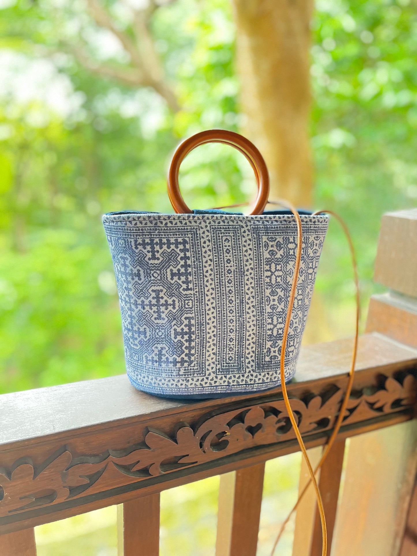 Handwoven vintage linen handle bag in Hmong indigo batik dyed art with solid wood handles. A rustic and ethnic plant dyed messenger bag.