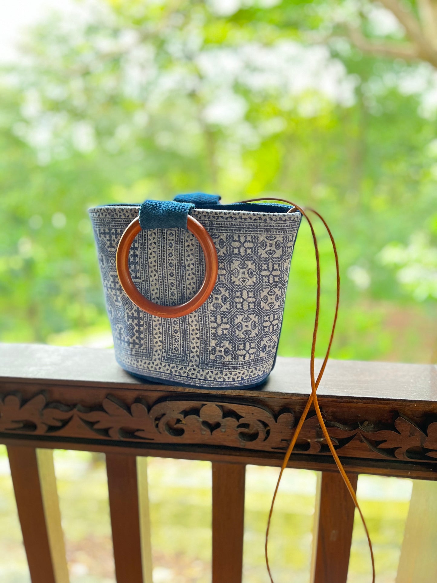 Handwoven vintage linen handle bag in Hmong indigo batik dyed art with solid wood handles. A rustic and ethnic plant dyed messenger bag.